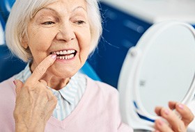 A woman looking at her mouth in the mirror