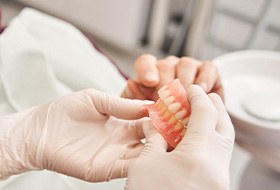 A dentist showing some dentures to her patient