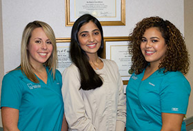 Dentist and team members smiling together