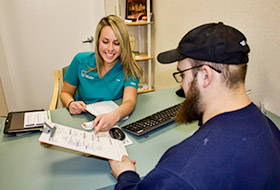 Team member showing dental patient paperwork