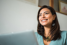 a smiling woman working on her laptop