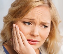 Woman holding jaw in pain