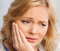 Woman holding jaw in pain