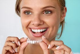 Woman placing Invisalign tray