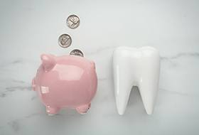 Close-up of a piggy bank and a tooth