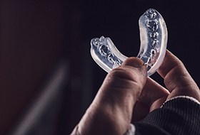 Man holding up clear mouthguard