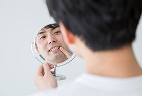 Man looking at smile in mirror