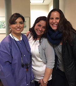 Dentist with two smiling patients