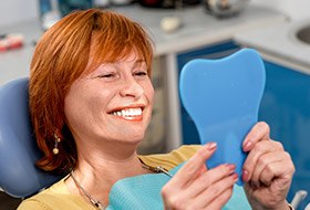 Older woman looking at smile in mirror