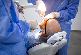 Dentist and patient looking at X-rays Two dentists in blue scrubs extracting a tooth