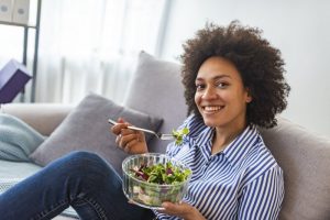 person on a couch eating a salad