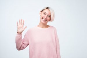 Smiling woman greets Wethersfield dentist with a wave in COVID-19
