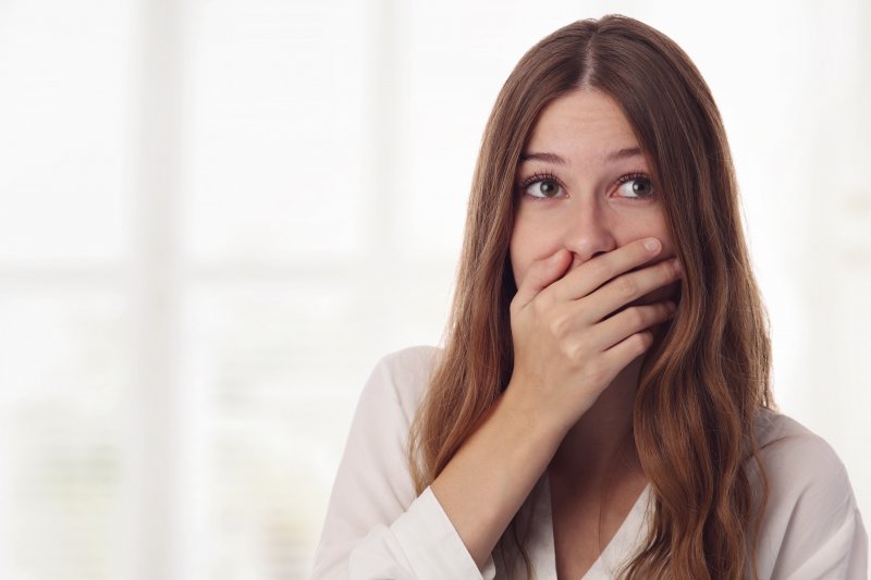 Young woman hiding her smile