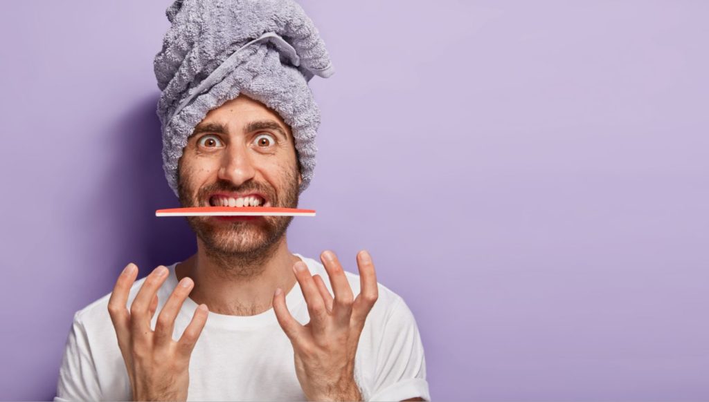 Man with nail file in his mouth