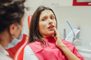 Woman with dental pain sitting in dentist's chair