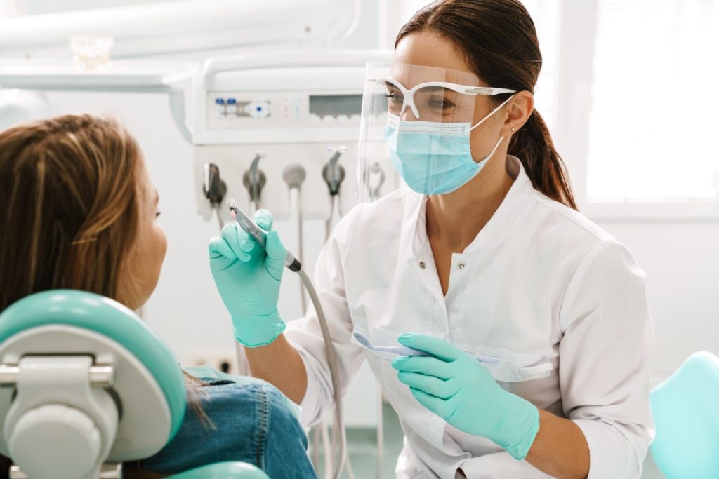 Cosmetic dentist smiling while talking to patient