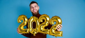 man with 2022 new year’s balloons  