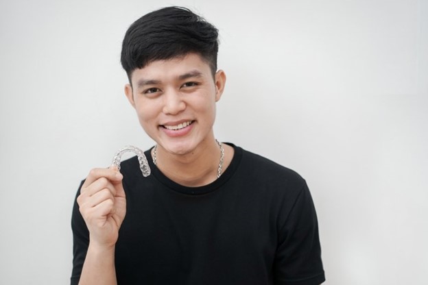 Man holding his clear aligner.