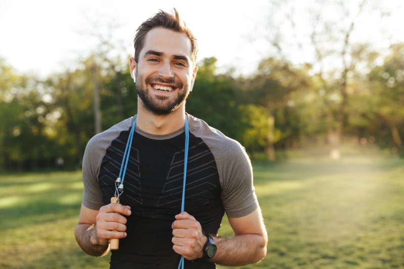 Smiling young man with fast metabolism exercising outdoors