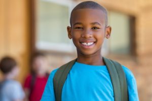 young boy with backpack smiling