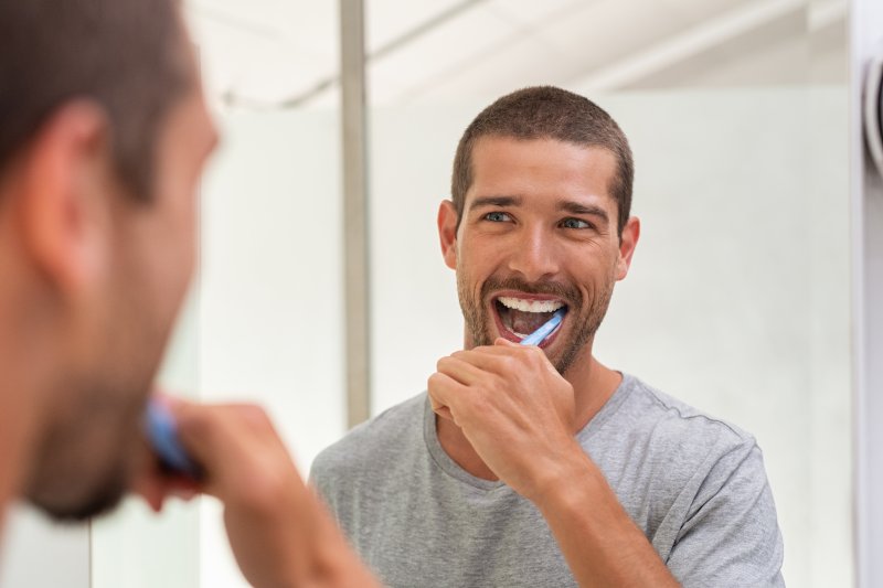 A man brushing his teeth before breakfast