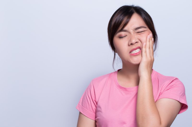 person holding cheek after biting it