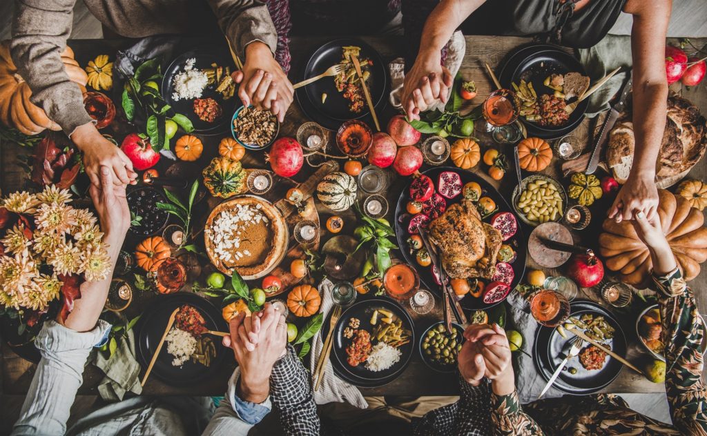 Family holding hands around Thanksgiving table