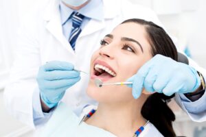 Woman with dark hair in dental chair about to have her teeth examined